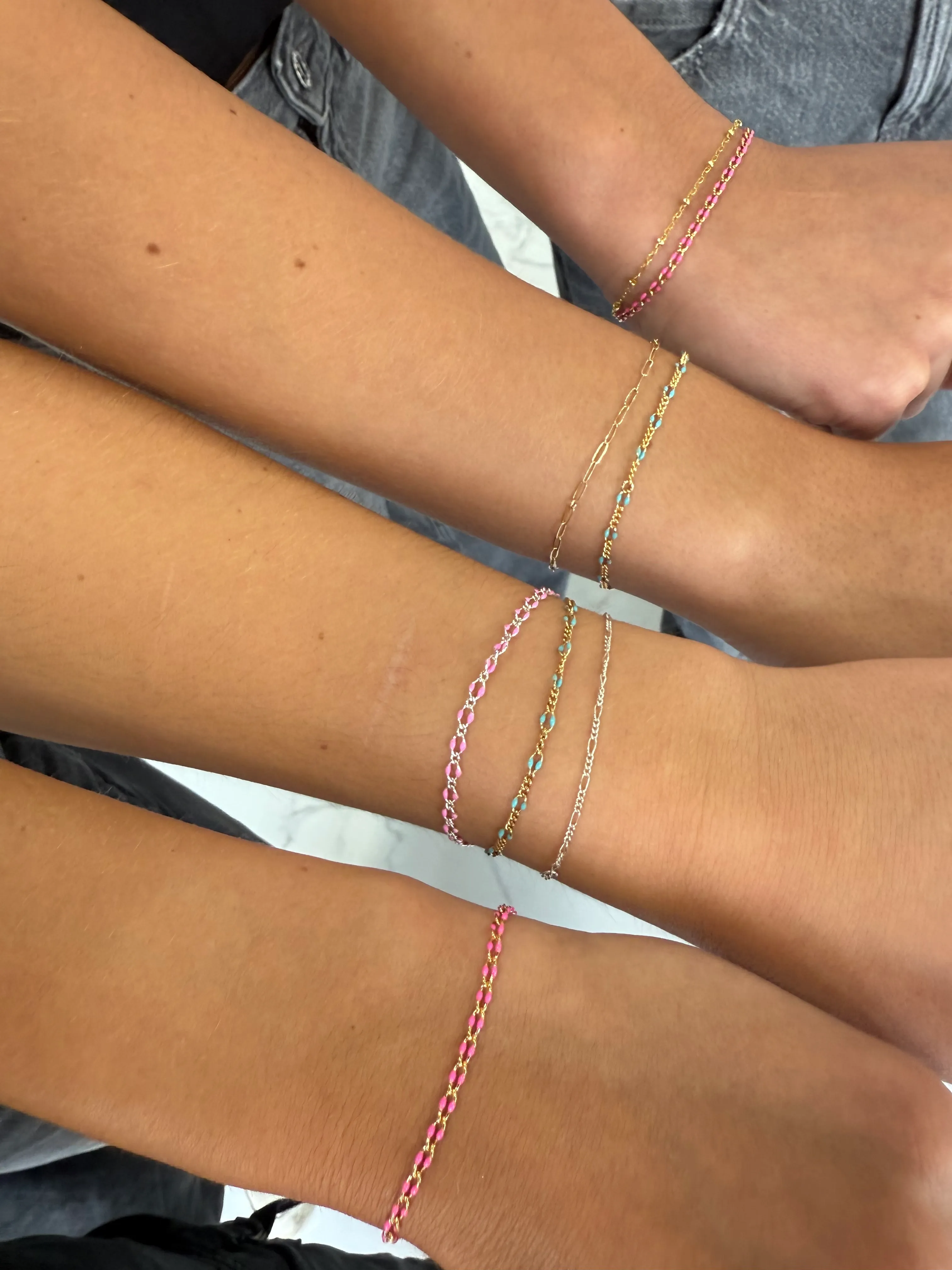 Four friends showing their matching bracelets