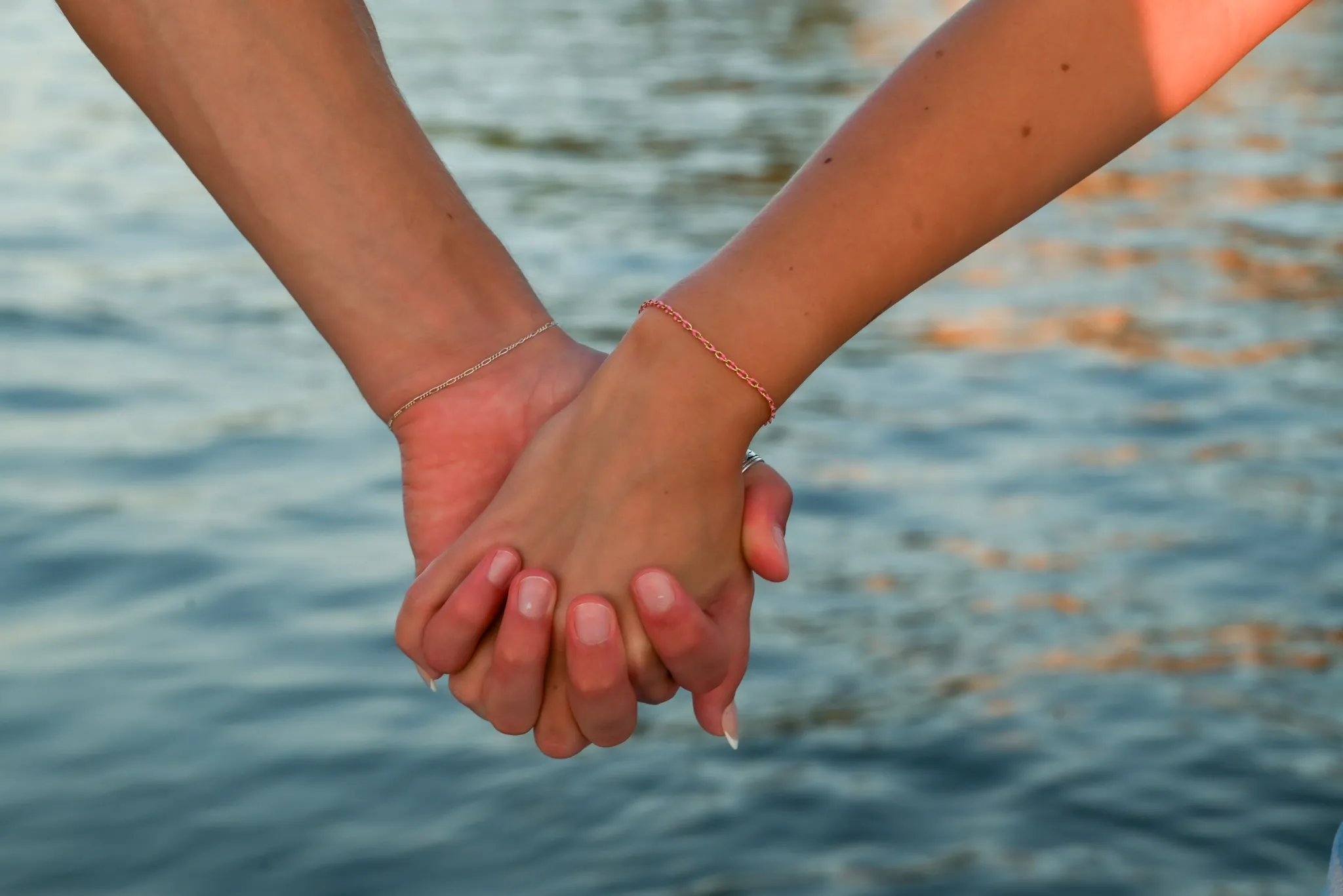 Couple holding hands with matching bracelets