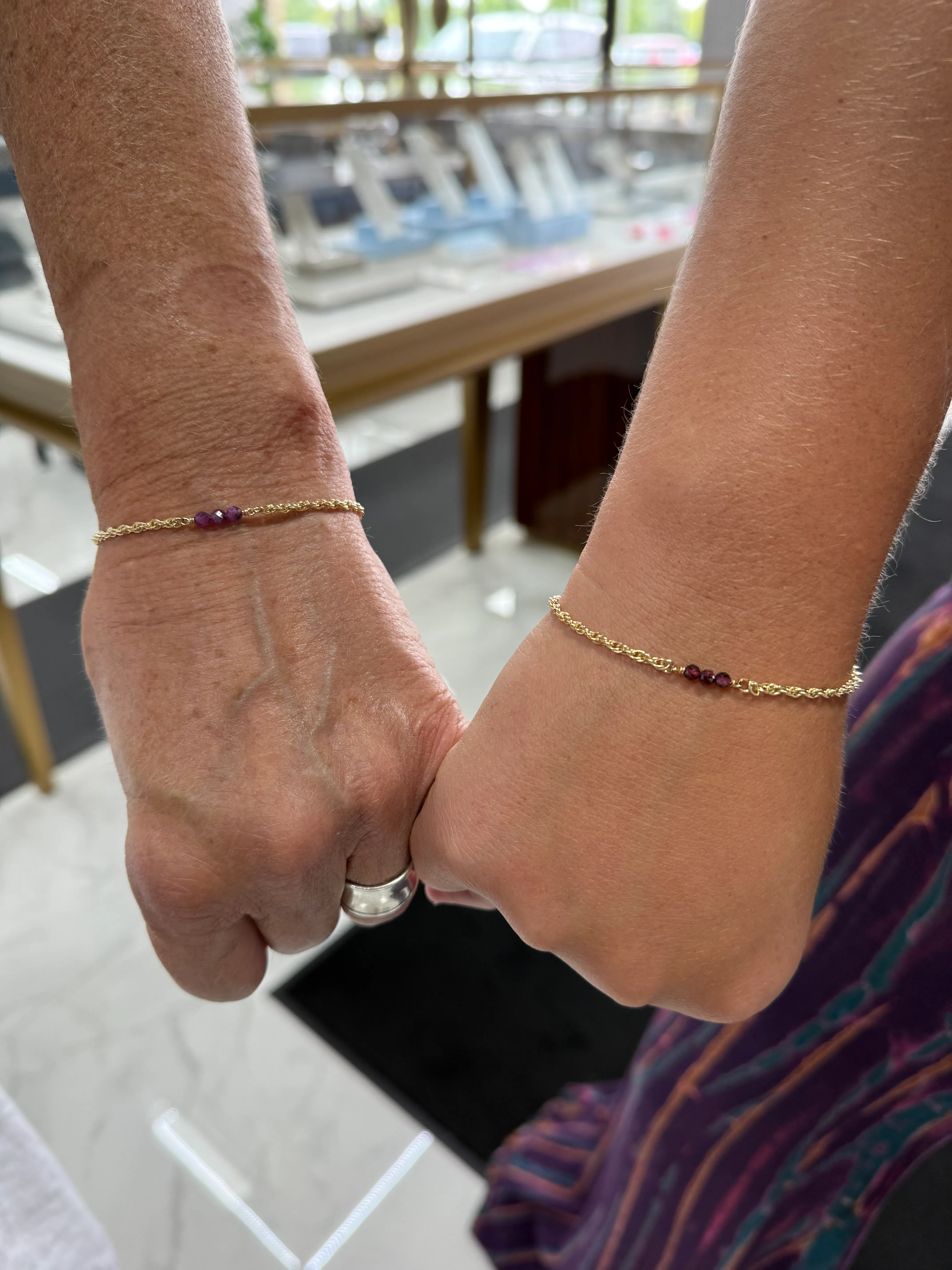 Mother and daughter holding hands with matching bracelets